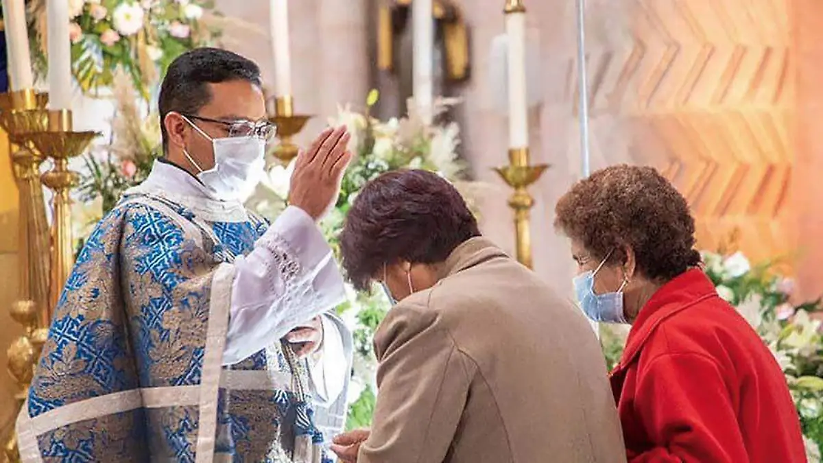 sacerdote imparte bendición a fieles en la Catedral Basílica